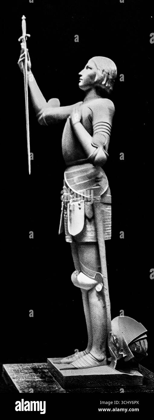 Foto in bianco e nero di una statua di Giovanna d'Arco che regge una spada rialzata, apparsa in l'Illustration il 17 giugno 1916. Presentata durante la prima guerra mondiale, l'immagine evocava orgoglio nazionale e devozione cattolica, raffigurando il santo come simbolo di sacrificio, coraggio e unità francese. Giovanna d'Arco servì come figura ispiratrice per il morale durante le difficoltà della grande Guerra. Foto Stock