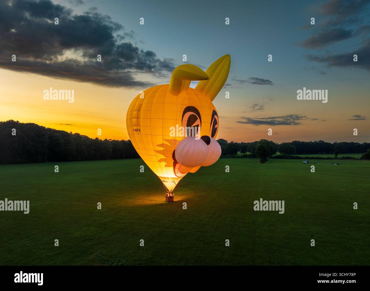 LOSSER, PAESI BASSI - 28 AGOSTO 2025: Pallone ad aria calda a forma di coniglio illuminato dal bruciatore a propano dopo l'atterraggio Foto Stock