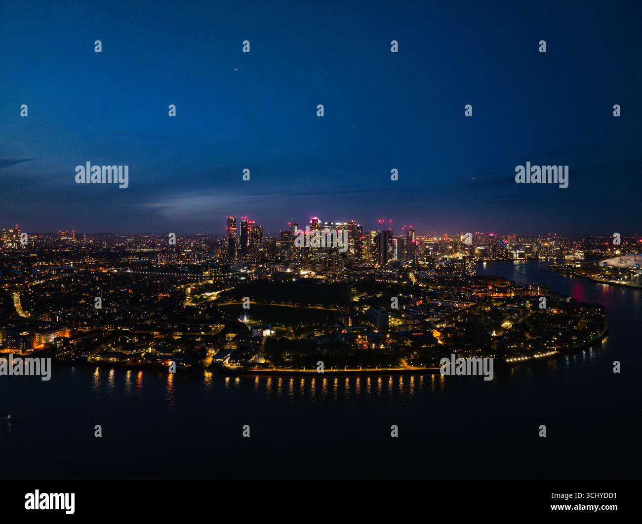 Una splendida vista di Londra di notte, caratterizzata da grattacieli illuminati e dal fiume Tamigi, con una vivace vita cittadina intorno. Foto Stock