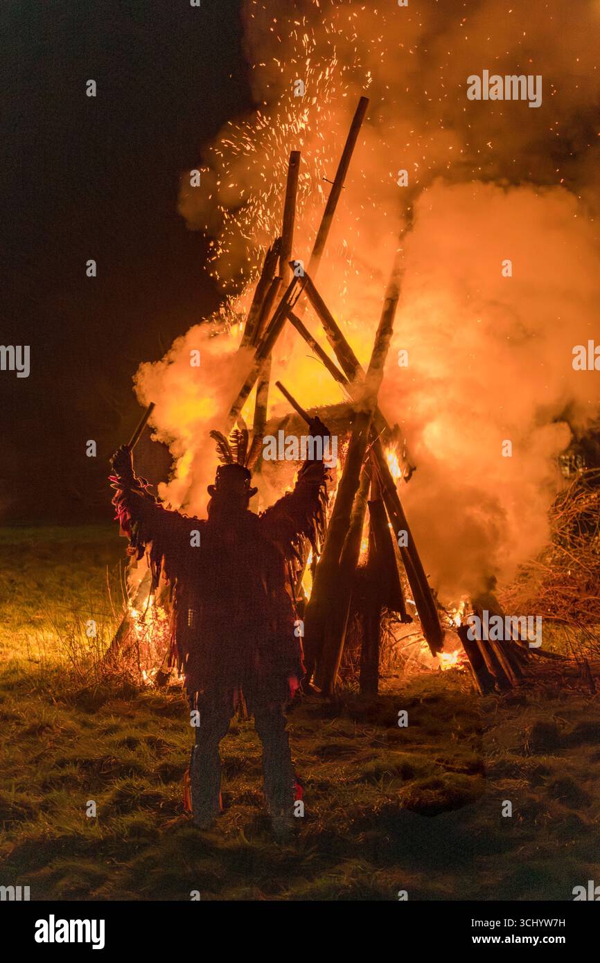 Un membro della squadra di ballo Foxgroupp Morris (o "Side") al rituale annuale invernale delle vele in un frutteto di mele da sidro a Monkland, Herefordshire, Regno Unito Foto Stock