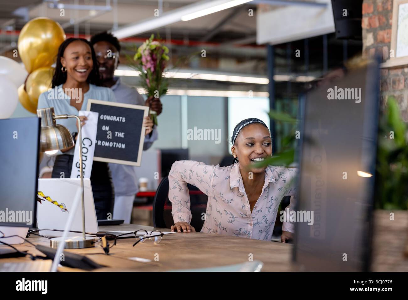Sorprendenti colleghi con fiori e segni, i colleghi celebrano la promozione in ufficio Foto Stock