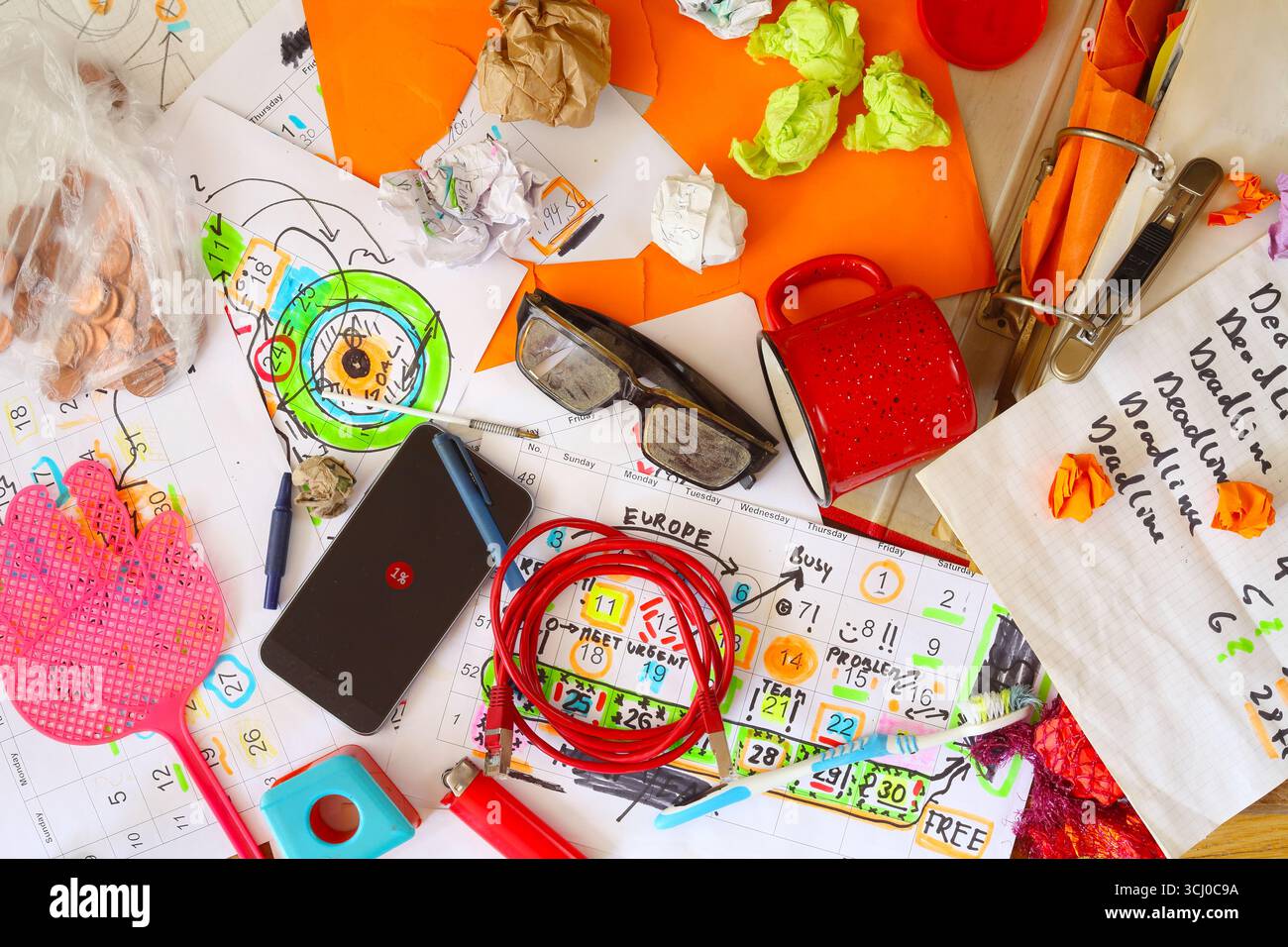 Posto di lavoro disordinato, ufficio caotico, superate le ore, superate le scadenze, lo stress, il concetto burocratico con una scrivania grungy e vari fogli di calendario e documenti Foto Stock