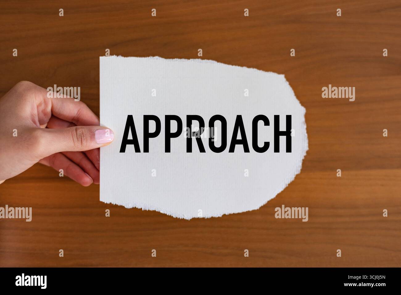 Approccio approccio. La mano della donna tiene un pezzo di carta con un biglietto, vintage. Metodo, strategia, procedura, piano, concetti. Note B1983 approccio Foto Stock