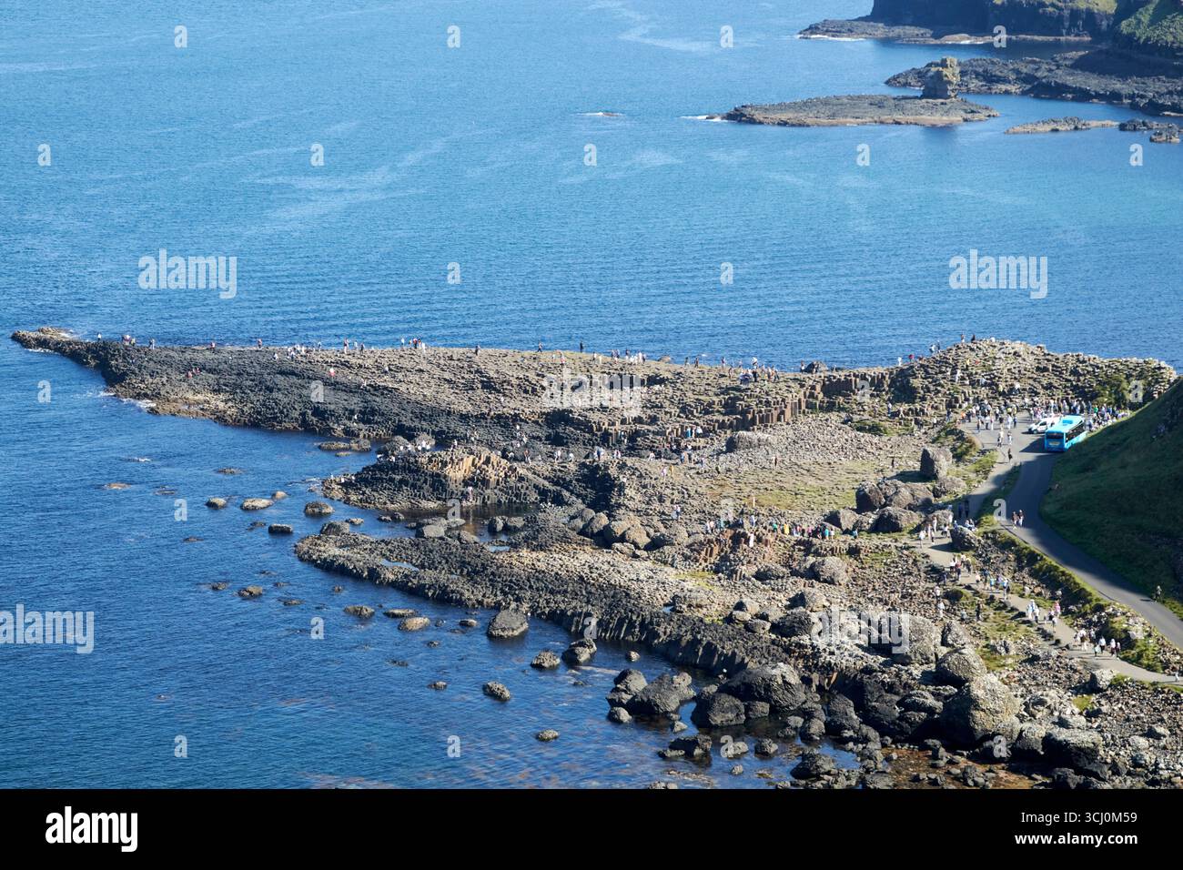 guardando in basso dal punto panoramico sul sentiero di scogliera superiore verso i turisti sulla strada rialzata gigante strada costiera della contea di antrim irlanda del nord regno unito Foto Stock