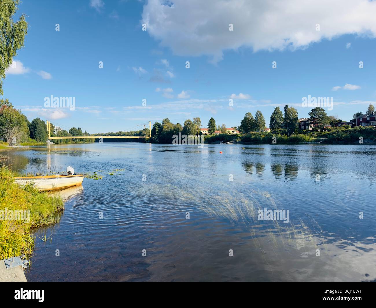 Vista panoramica di un fiume con un ponte sotto un cielo blu Foto Stock