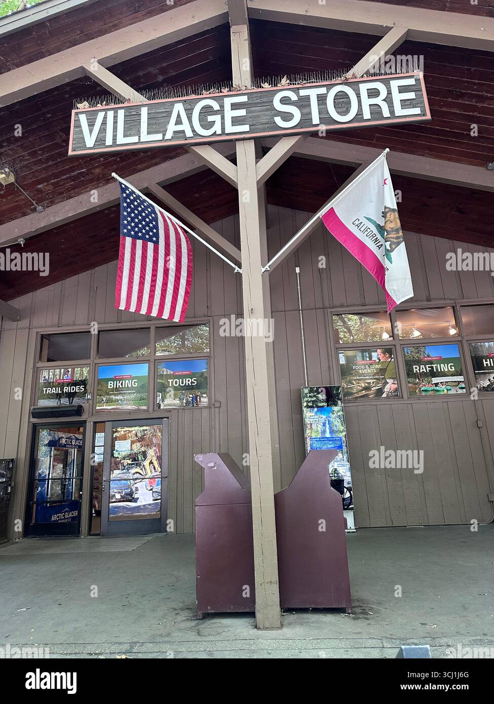 Parco nazionale di Yosemite, California, Stati Uniti. 4 settembre 2025. Vista d'ingresso del Village Store con le bandiere degli Stati Uniti e della California - Immagine stock catturata con smartphone