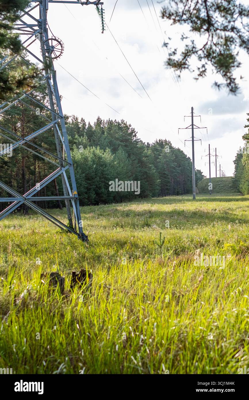 La torre Power è caratterizzata da un vivace paesaggio verde, con alberi che fiancheggiano lo sfondo, che mostrano l'armonia della natura e dell'industria Foto Stock