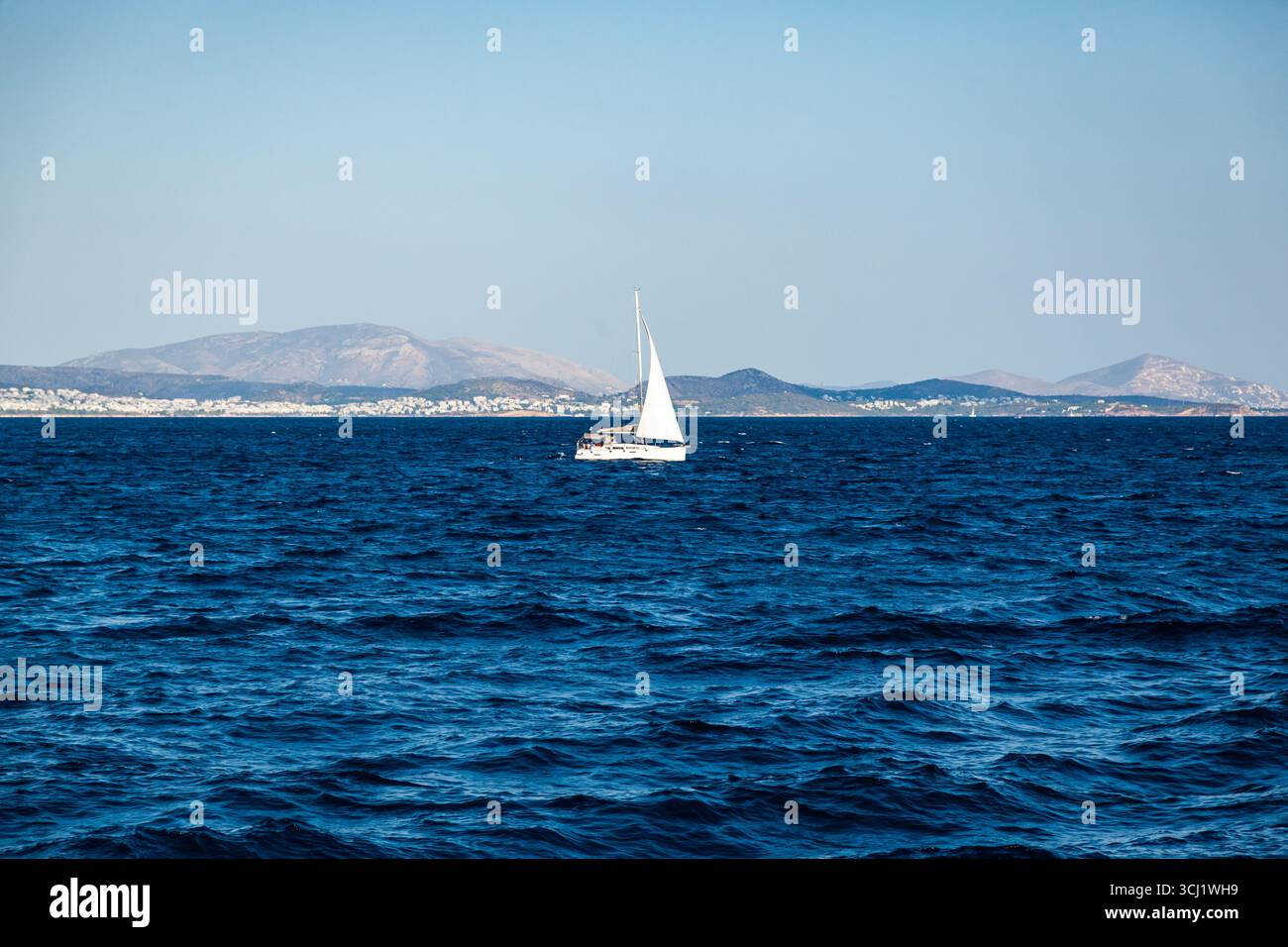 Yacht a vela nella baia di mare sullo sfondo delle montagne al largo della costa greca. Foto Stock