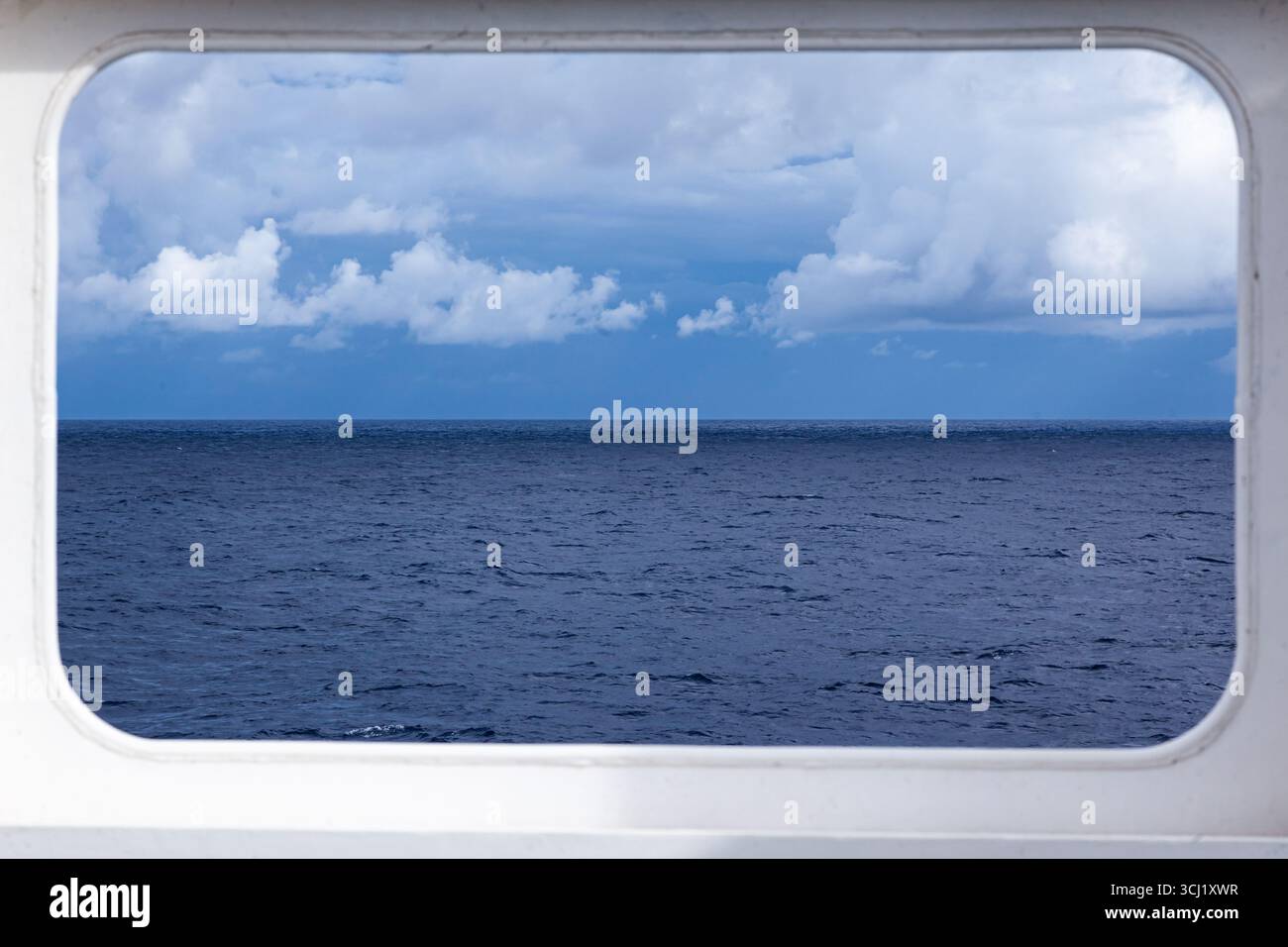 Finestra rettangolare in acciaio su una nave che si affaccia sul mare aperto e sul cielo. Foto Stock