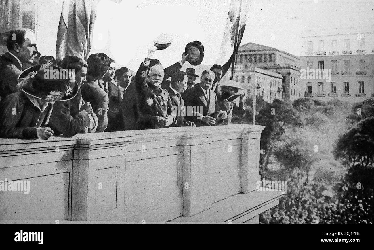 Pubblicata su le Miroir nel 1916, questa scena mostra l'ammiraglio Louis Dartige du Fournet, comandante delle flotte alleate, rivolgendosi a una folla dal balcone del municipio del Pireo, in Grecia. Accompagnato dal sindaco, l'ammiraglio francese rispose al plauso popolare durante il turbolento periodo di guerra nel Mediterraneo orientale. L’evento evidenzia l’importanza strategica della Grecia e il ruolo simbolico della potenza navale alleata nella diplomazia della prima guerra mondiale. Foto Stock