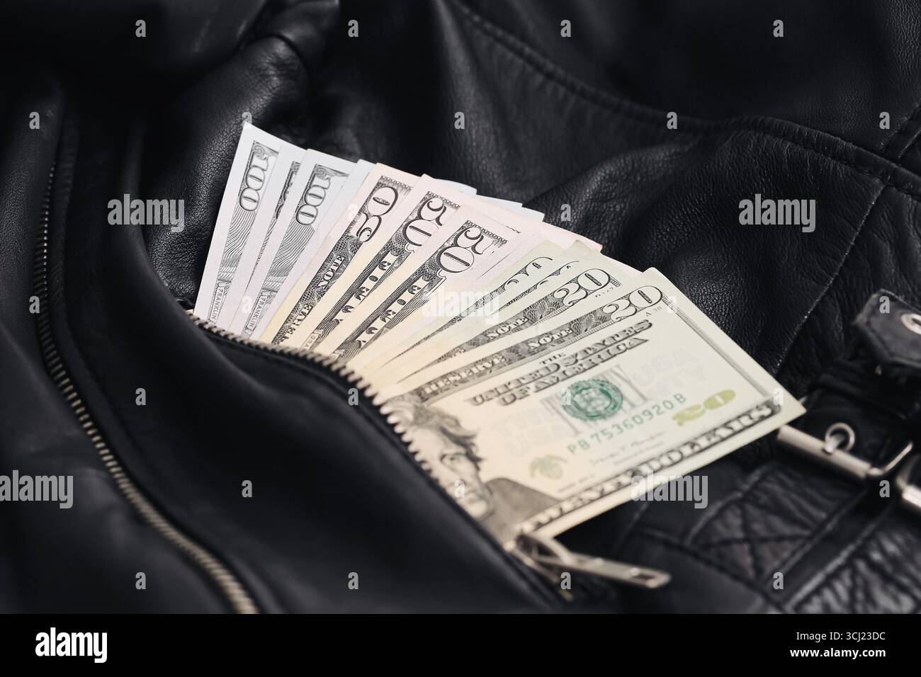 Dollari USA in giacca di pelle. Soldi nascosti in tasca. Risparmio di denaro e concetto finanziario. Simbolo di ricchezza ed economia. Le banconote in valuta americana chiudono Foto Stock