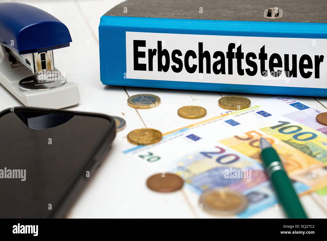 Germania - 4 settembre 2025: FOTOMONTAGGIO, Una cartella blu denominata tassa di successione si trova tra le banconote e le monete in euro. L'immagine illustra il dibattito politico che circonda la tassazione delle successioni e la questione di un'equa distribuzione della ricchezza. *** FOTOMONTAGE, Ein blauer Ordner mit der Aufschrift Erbschaftsteuer liegt zwischen Euro-Scheinen und Münzen. DAS Bild verdeutlicht die politische debatte um die Besteuerung von Erbschaften und die Frage nach gerechter Vermögensverteilung. Foto Stock