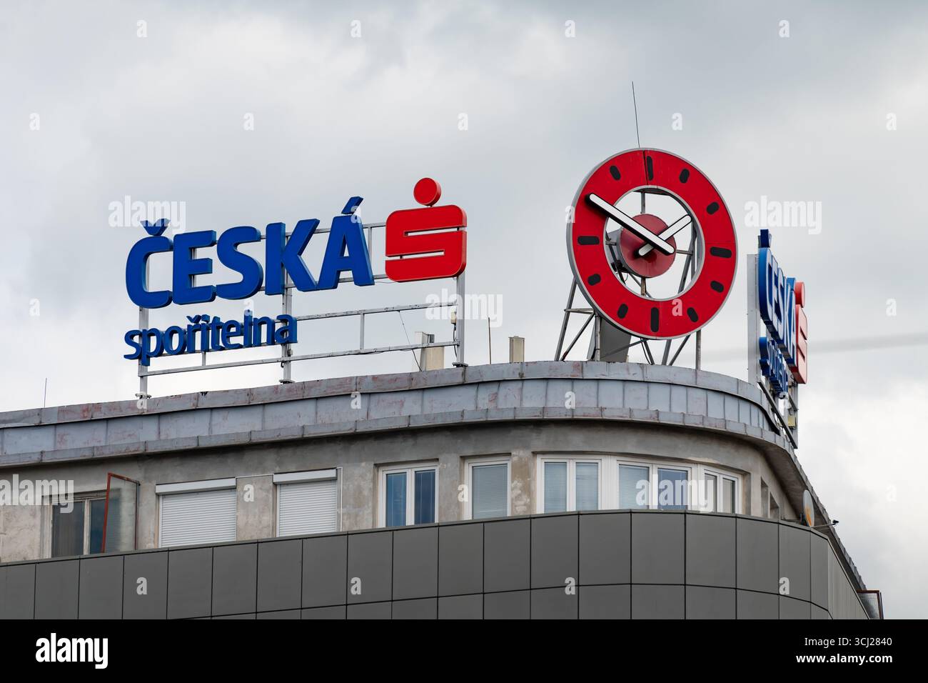Česká spořitelna (Cassa di risparmio ceca) all'esterno dell'edificio. Servizi finanziari per i cittadini della Repubblica ceca. Casa con un orologio rosso. Foto Stock