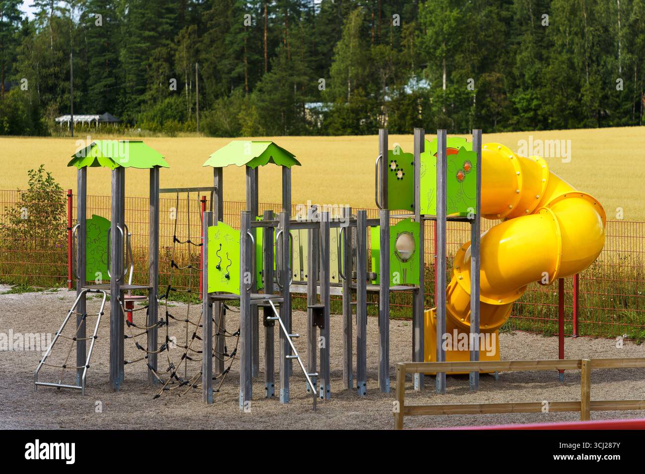 Orimattila, Finlandia - 10 agosto 2025 - parco giochi dell'asilo vicino a un campo d'oro Foto Stock