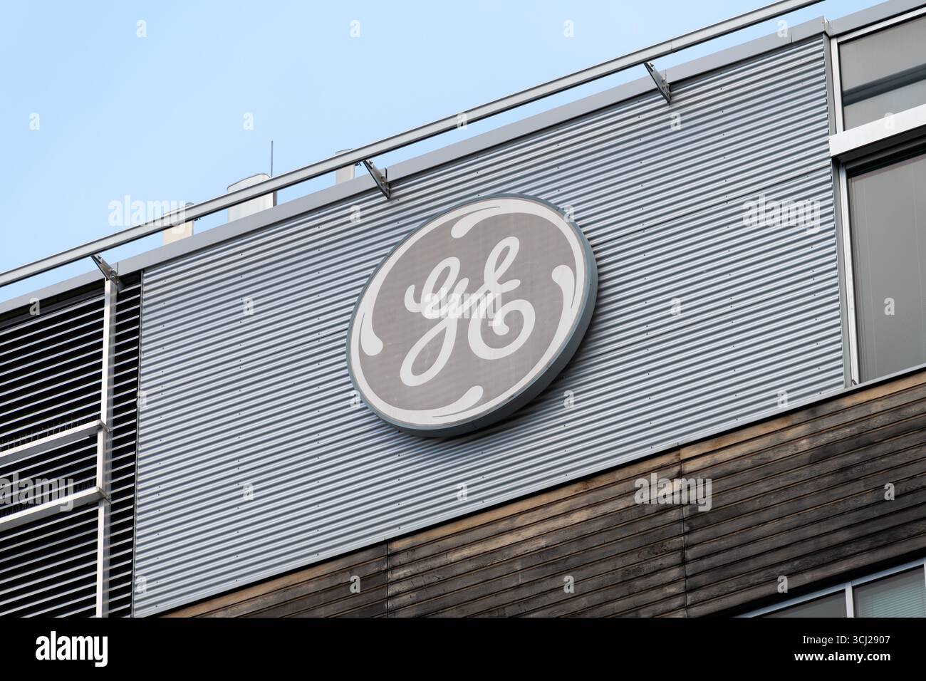 Logo GE (General Electric) sulla facciata di un edificio. Primo piano della segnaletica aziendale sull'esterno dell'ufficio in Europa. Azienda industriale come datore di lavoro Foto Stock