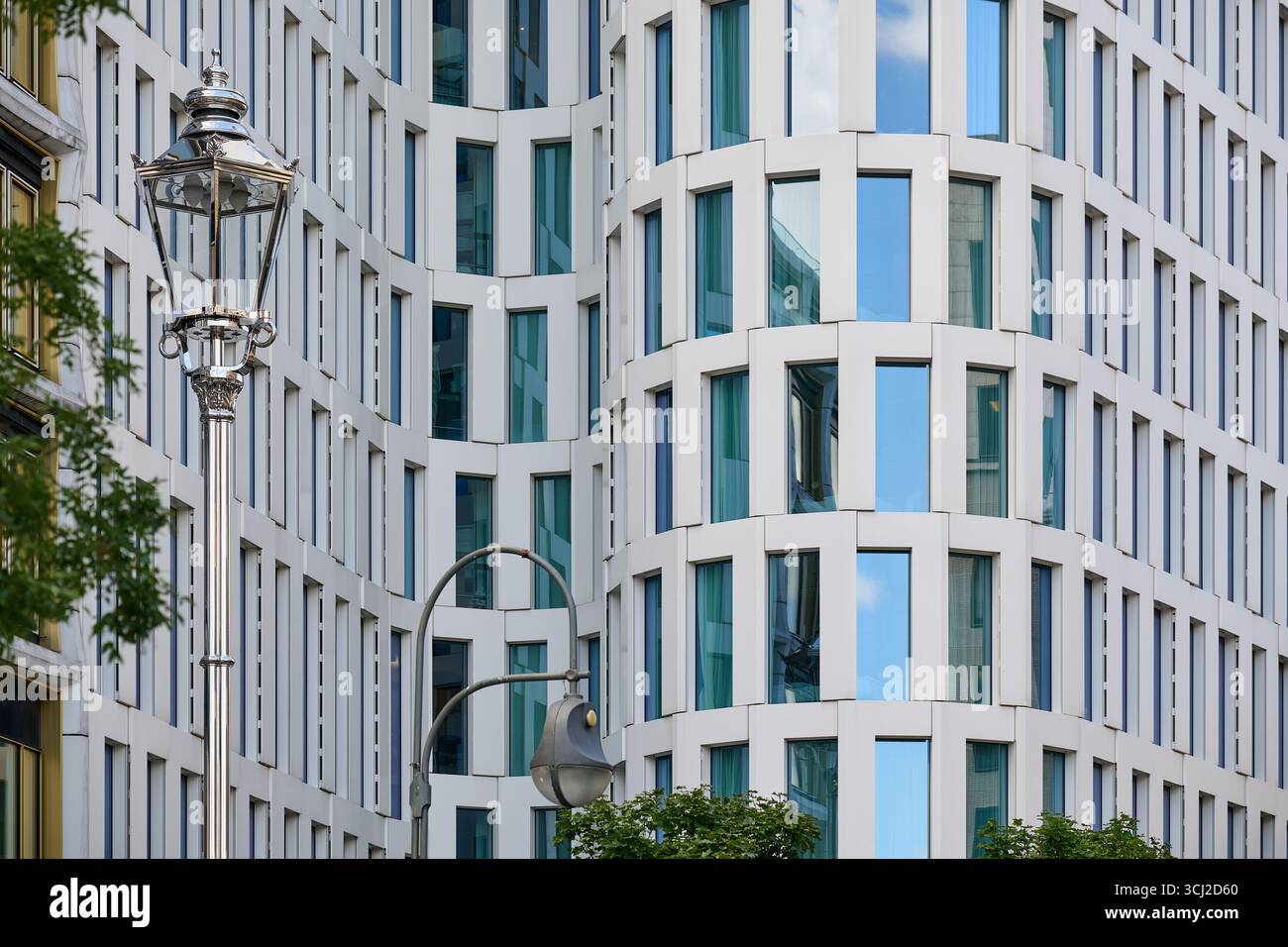 Facciata di un alto e moderno edificio per uffici con curve bianche e finestre in vetro a Berlino, luce naturale, composizione verticale, perfetto per immobili, architec Foto Stock