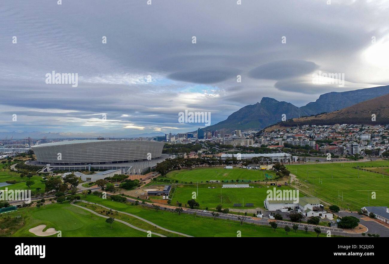 Uno scatto aereo dello stadio di città del Capo e dei suoi campi verdi circostanti. La particolare formazione di nubi in questa foto è una nuvola lenticolare. Foto Stock