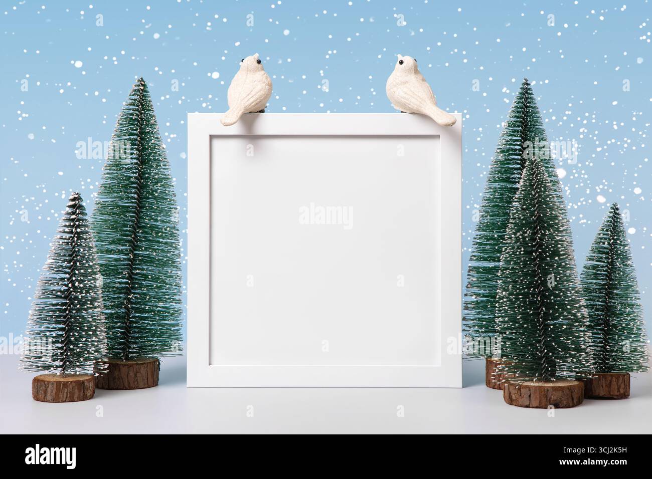 Sfondo natalizio con alberi di Natale, uccelli bianchi e cornice bianca per testo, saluti, promozioni e sconti. Biglietto di Natale e Capodanno. Foto Stock