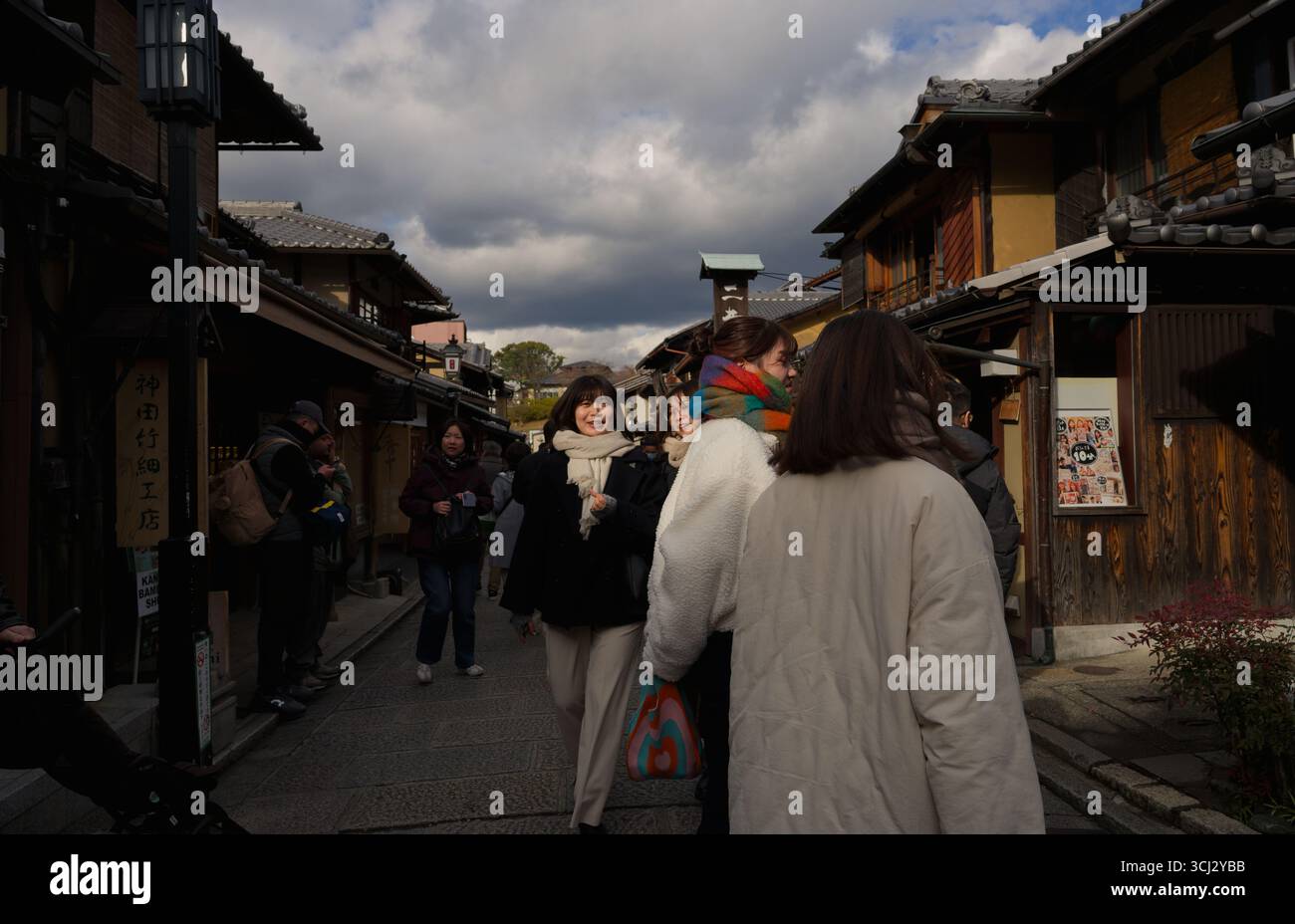 Pomeriggio invernale nel quartiere Higashiyama di Kyoto, la luce soffusa taglia attraverso le nuvole drammatiche, illuminando la gente del posto e i visitatori Foto Stock