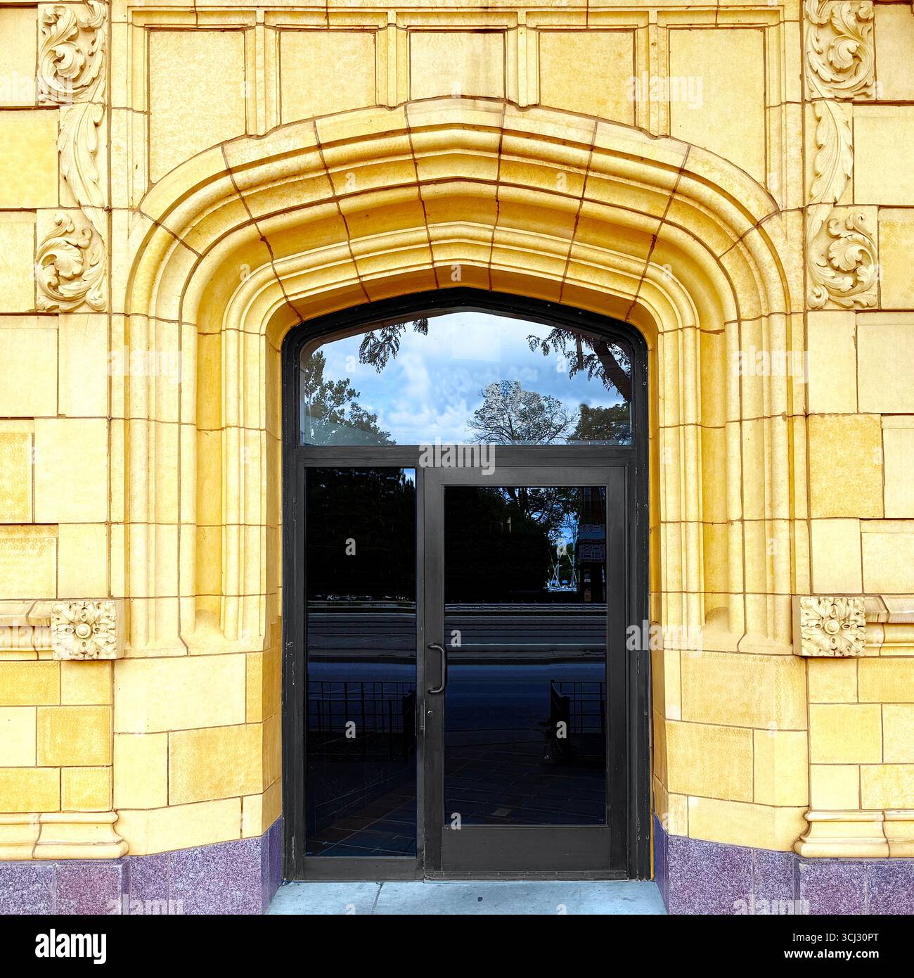 Porta di Chicago incorniciata da un arco gotico ornato con facciata in pietra dorata. - Immagine stock catturata con smartphone