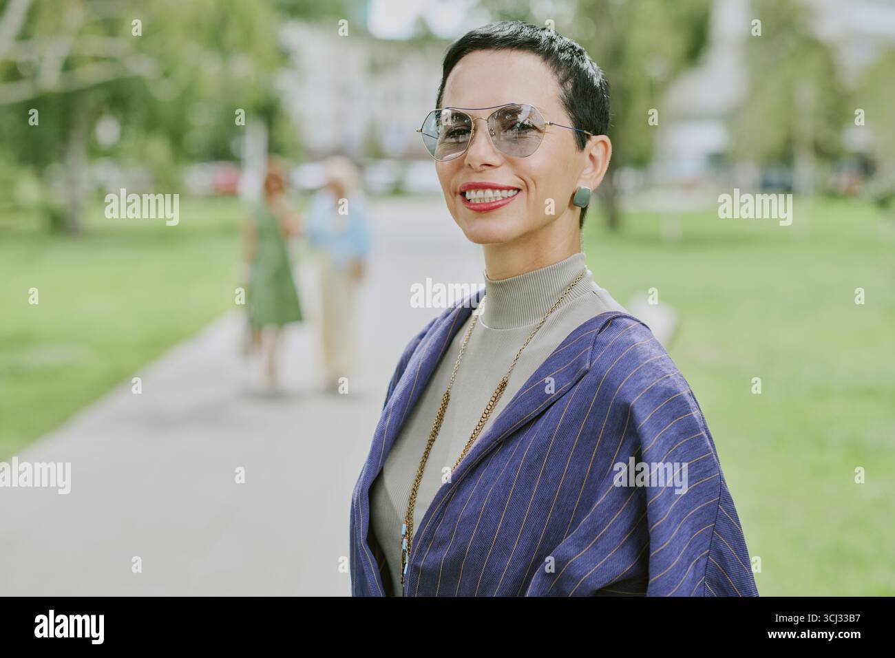 Ritratto di una donna di mezza età che sorride con fiducia a City Park Foto Stock