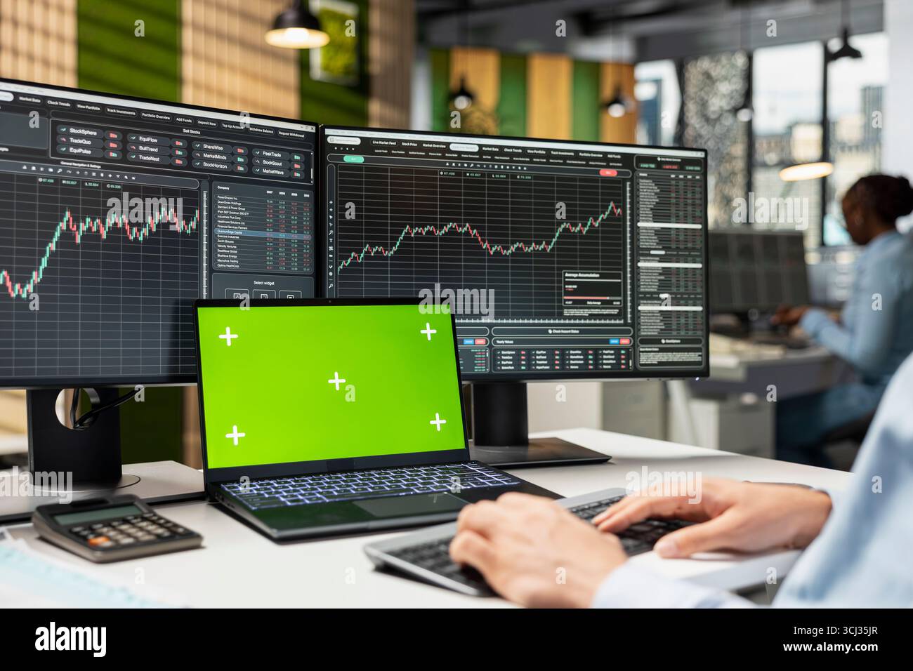 Trader che controlla i prezzi delle borse in ufficio utilizzando un laptop con modello green screen, negoziando titoli. Lavoratore che utilizza la piattaforma di trading su notebook Chroma Key per modificare la strategia di acquisto Foto Stock