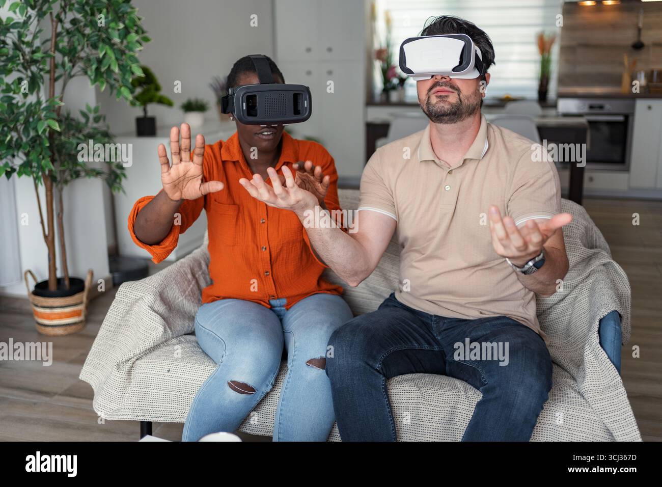 Coppia che esplora la realtà virtuale utilizzando i visori vr a casa Foto Stock