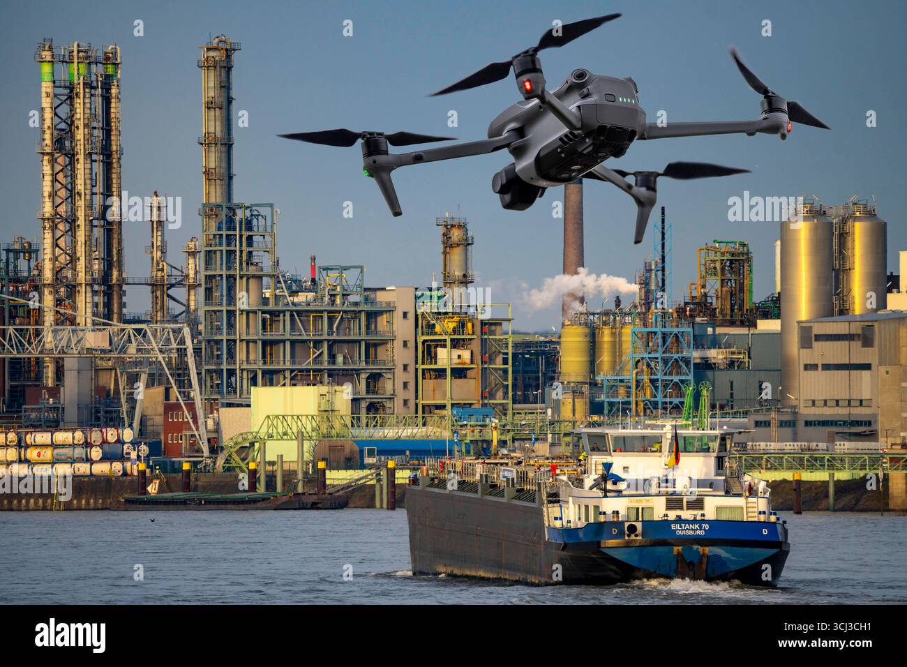 Symbolbild, Fotomontage, Aufklärung, Spionage mit Drohnen in Industrieanlagen, kritischer Infrastruktur, Drohne fliegt auf einen Industriekomplex zu, Chemiewerk, Ausspähen durch Kameradrohnen, Drohnen Spionage *** immagine simbolica, fotomontaggio, ricognizione, spionaggio con droni in impianti industriali Foto Stock