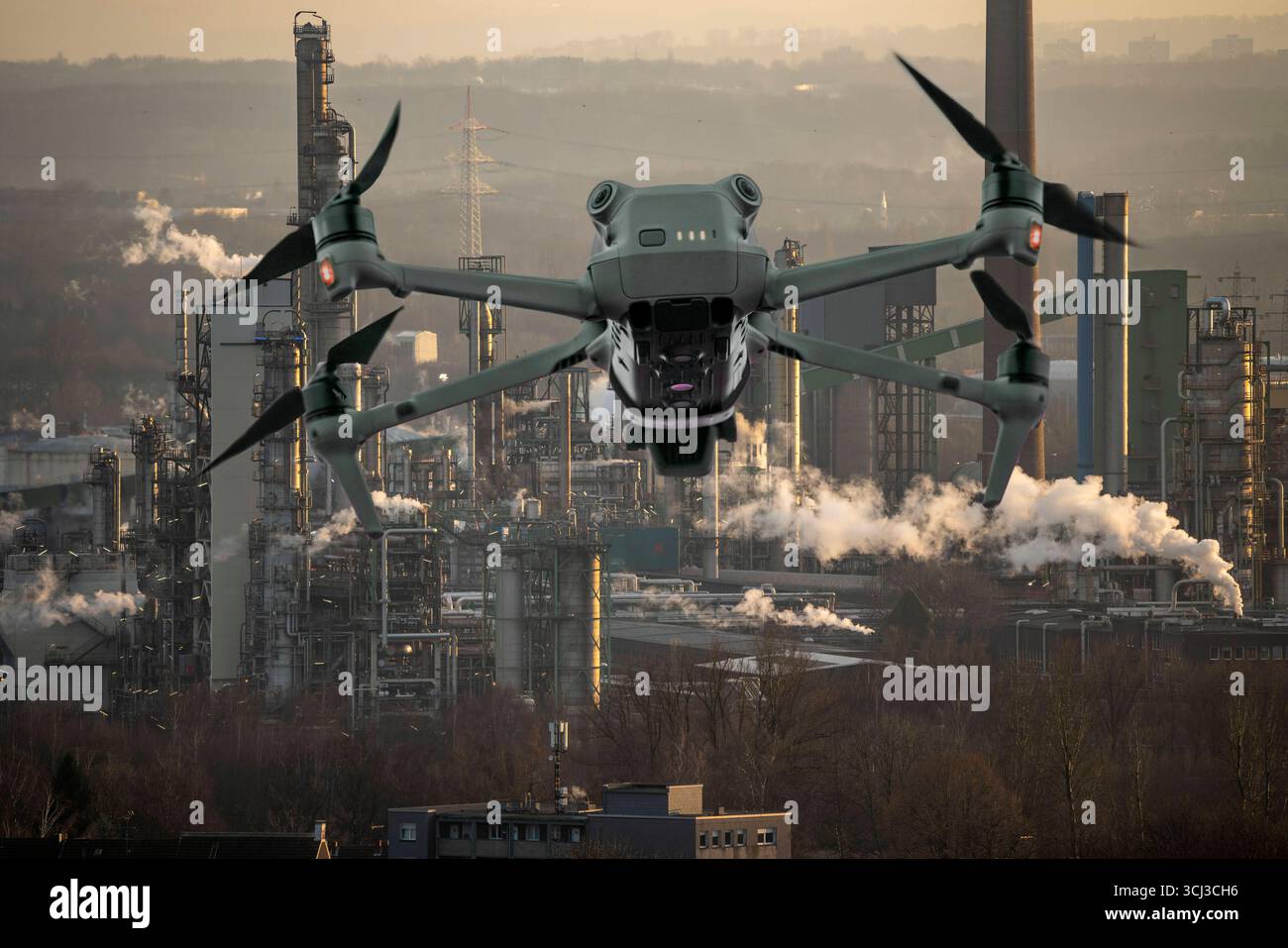 Symbolbild, Fotomontage, Aufklärung, Spionage mit Drohnen in Industrieanlagen, kritischer Infrastruktur, Drohne fliegt auf einen Industriekomplex zu, Chemiewerk, Ausspähen durch Kameradrohnen, Drohnen Spionage *** immagine simbolica, fotomontaggio, ricognizione, spionaggio con droni in impianti industriali Foto Stock