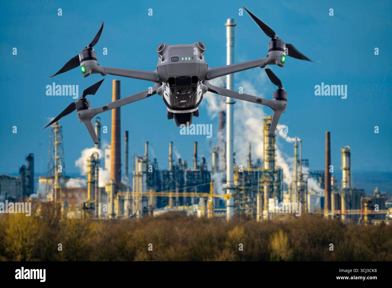 Symbolbild, Fotomontage, Aufklärung, Spionage mit Drohnen in Industrieanlagen, kritischer Infrastruktur, Drohne fliegt auf einen Industriekomplex zu, Chemiewerk, Ausspähen durch Kameradrohnen, Drohnen Spionage *** immagine simbolica, fotomontaggio, ricognizione, spionaggio con droni in impianti industriali Foto Stock