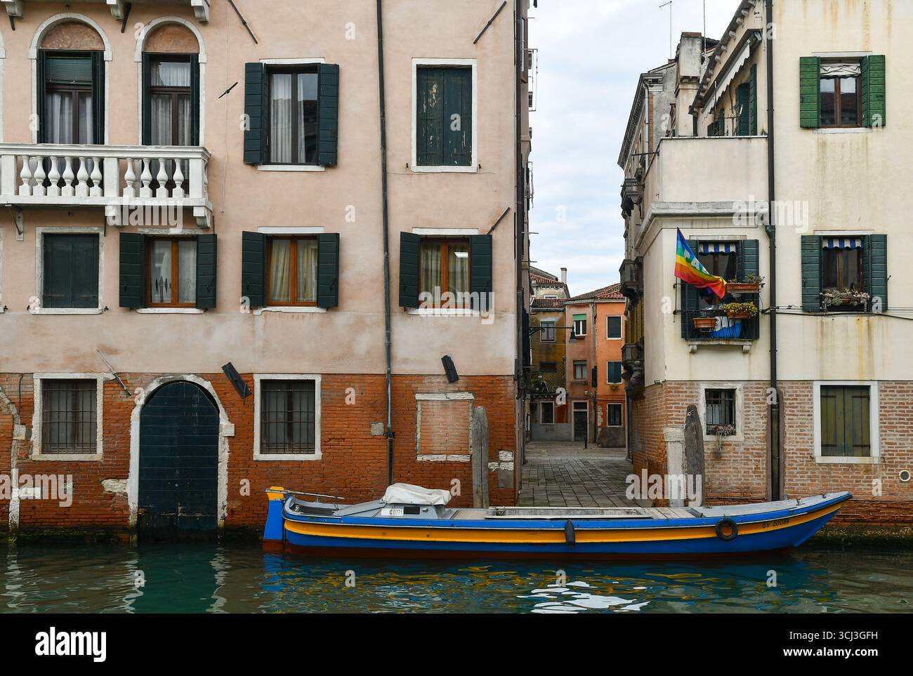 Una colorata nave cargo ormeggiata sul Rio dei Mendicanti, con Corte del Paludo sullo sfondo, nel sestiere di Cannaregio, Venezia, Veneto, italia Foto Stock