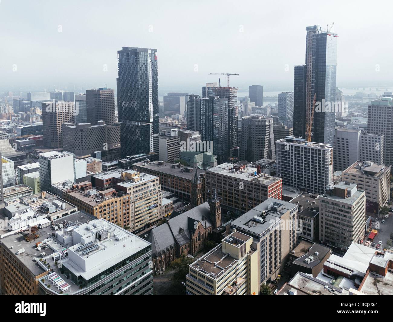 Volo in droni nello skyline del centro città, vista nebbiosa diurna di Montreal, Quebec, Canada Foto Stock