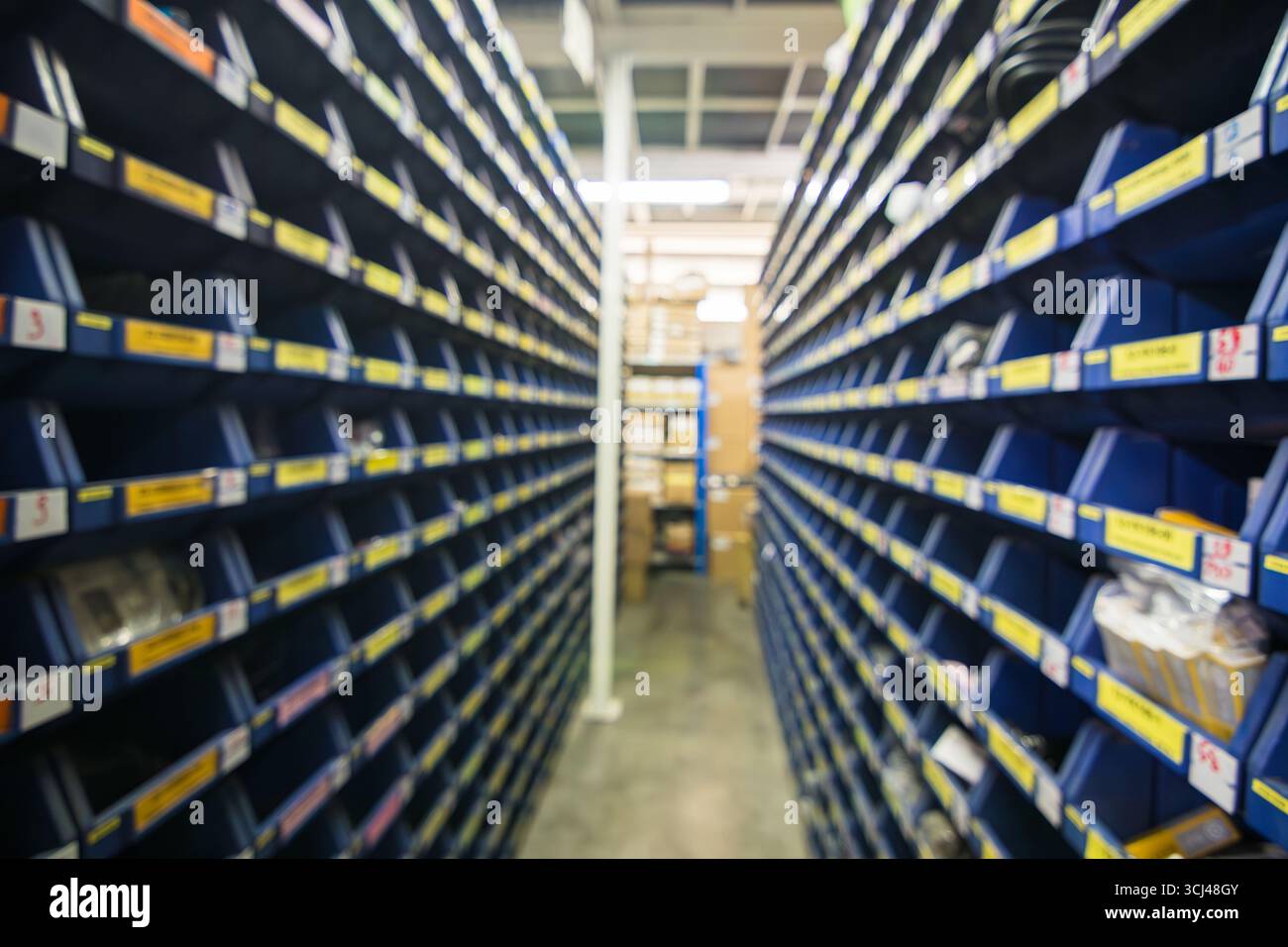 Sfocatura dello spazio di immagazzinamento delle parti in fabbrica industriale magazzino magazzino di componenti elettronici e scaffale delle parti di macchine per lo sfondo Foto Stock