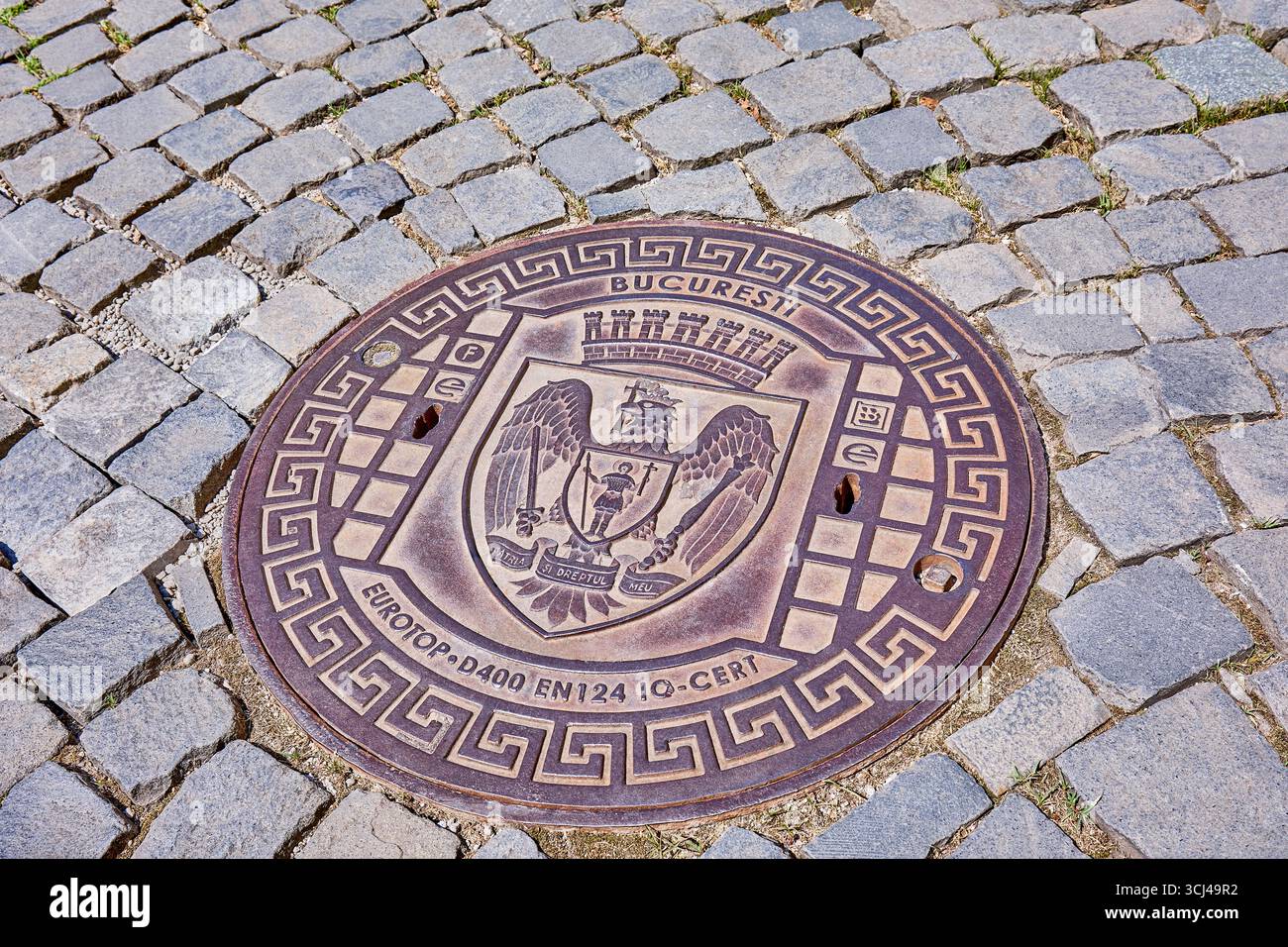 Buca di Bucarest con stemma su strada acciottolata nel centro storico di Bucarest, Romania, Europa Foto Stock