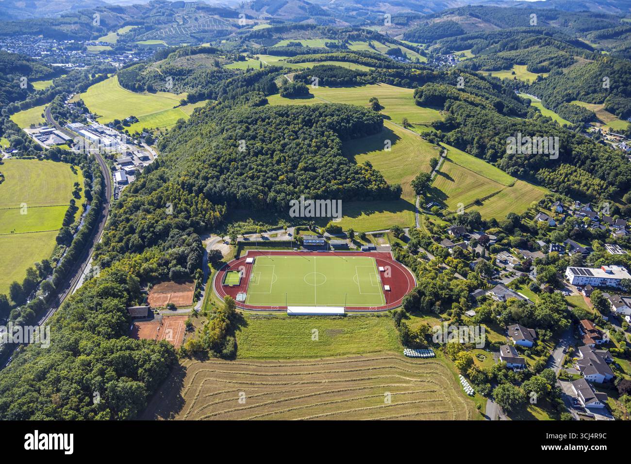 Vista aerea, stadio di calcio e atletica, stadio all'Habuche e campo da tennis TC Grevenbrueck 1975, paesaggio collinare e foresta, sul Foto Stock