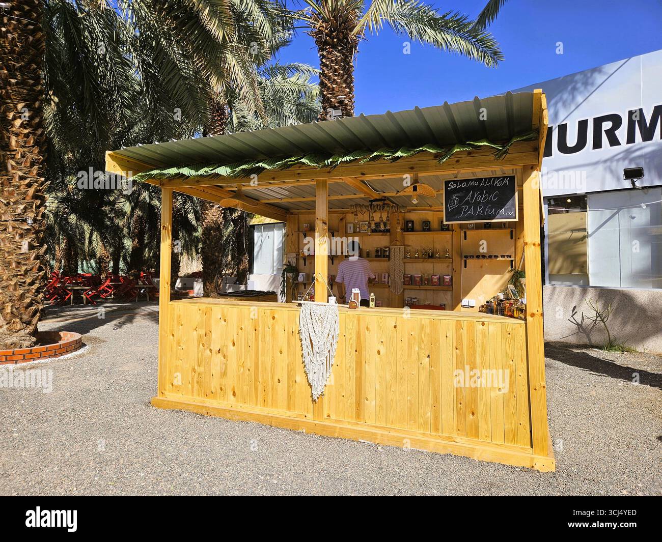 Il chiosco vicino alla piantagione di palme da dattero vende diversi prodotti. Madinah, Arabia Saudita - 6 marzo 2024 - Immagine stock catturata con smartphone