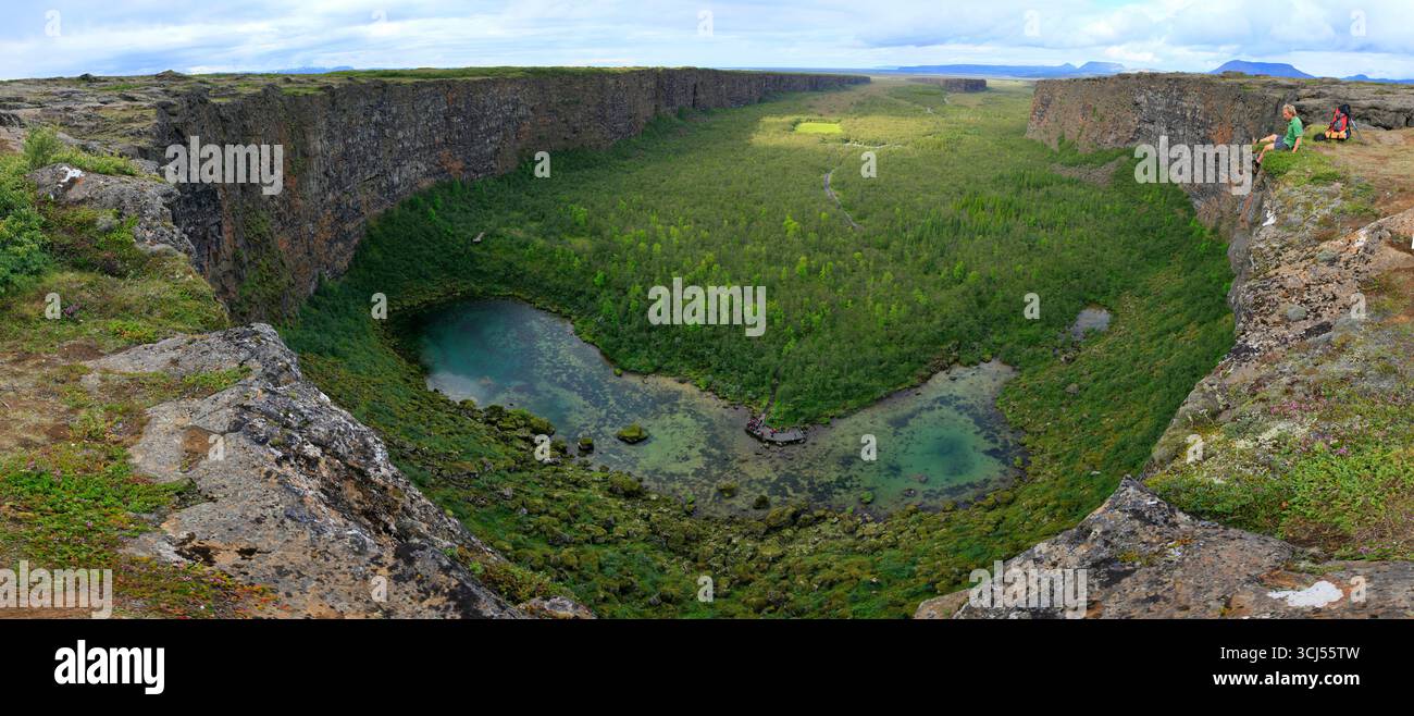 Escursionista seduto ai margini del canyon Asberygi, del parco nazionale Jokulsargljufur, Islanda Foto Stock