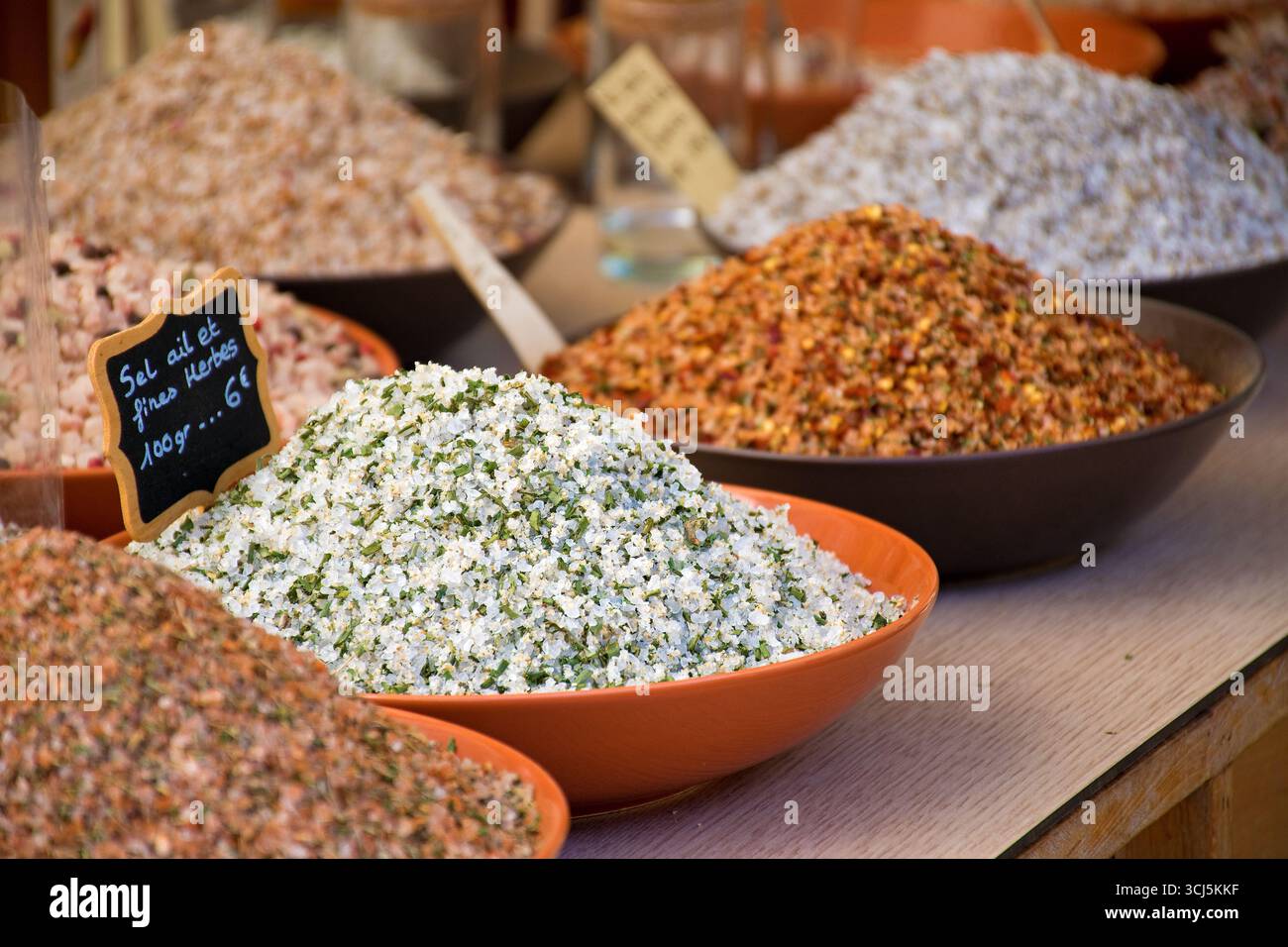 Mercato in Provenza. Bancarelle di mercato con erbe colorate etichettate: "Sale d'aglio con erbe". Foto Stock