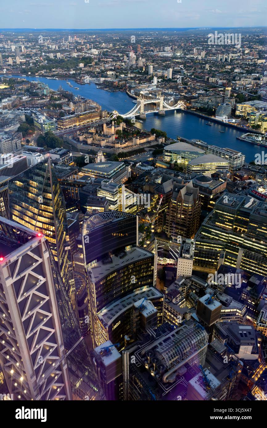 Lo skyline di Londra al crepuscolo. La Torre di Londra e il Tower Bridge sono visibili sul Tamigi, circondati da moderni grattacieli. Foto Stock