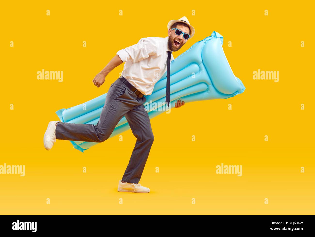 Lavoratore d'ufficio felice e divertente che tiene il materasso da spiaggia e corre su sfondo giallo Foto Stock