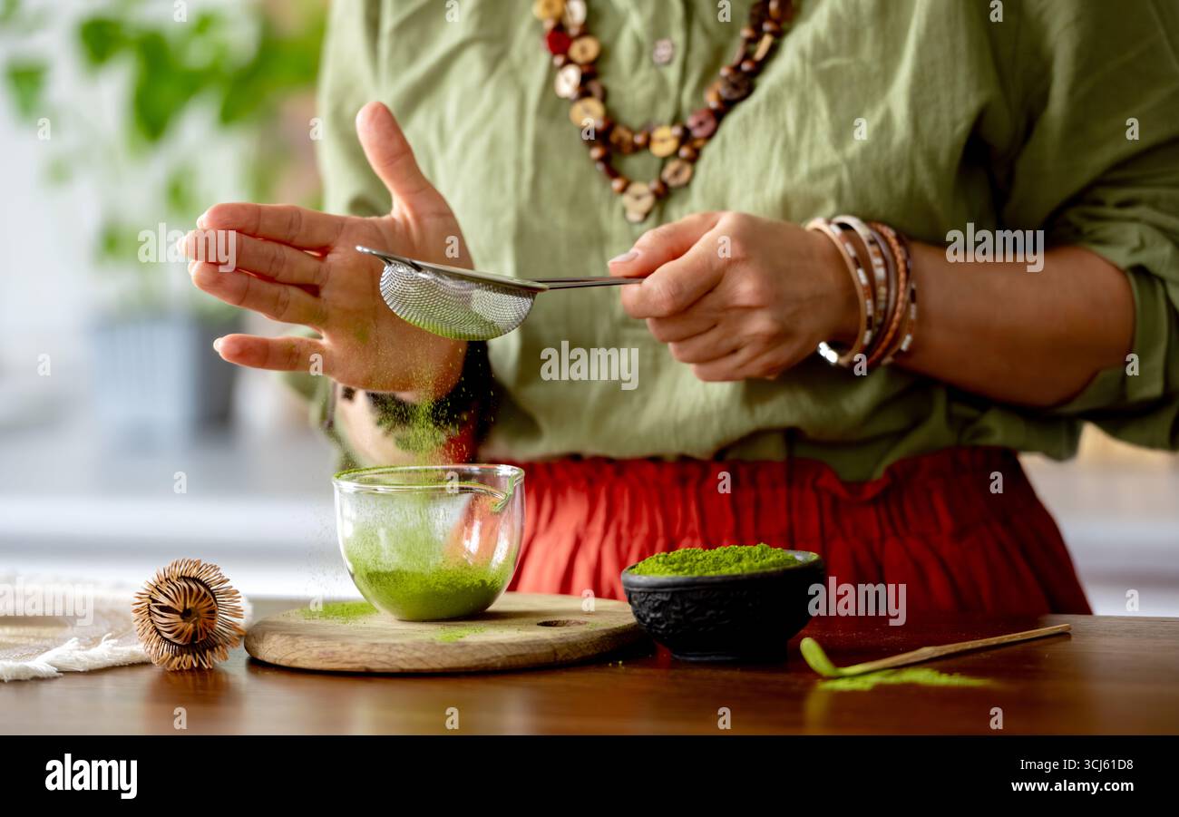 Donna che prepara tè verde Matcha Close-up View Sifting Tea Foto Stock