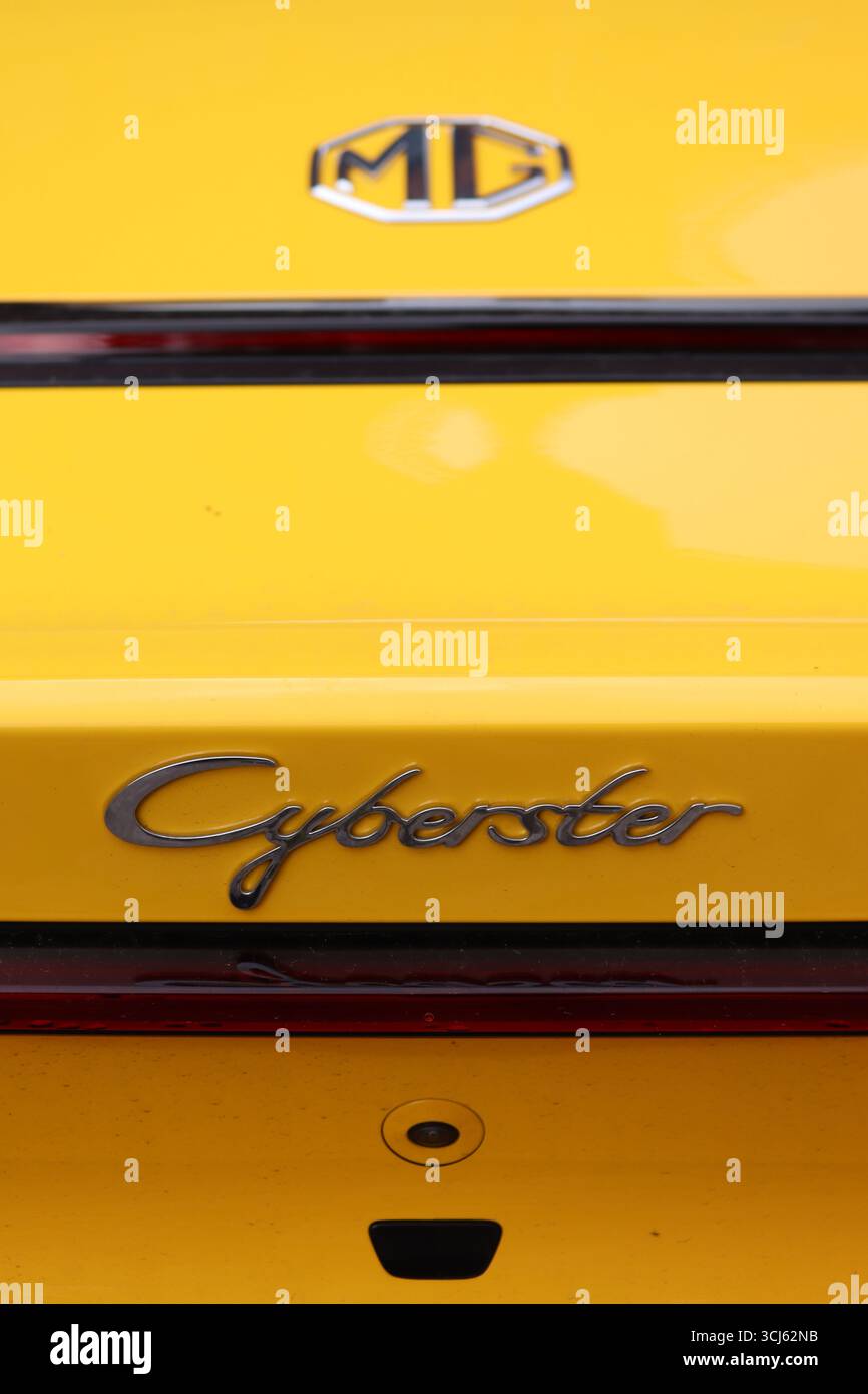 Vista posteriore di un'auto sportiva elettrica a due posti MG Cyberster, che mostra il dettaglio cromato del logo MG e il carattere del testo del nome dell'auto. Foto Stock