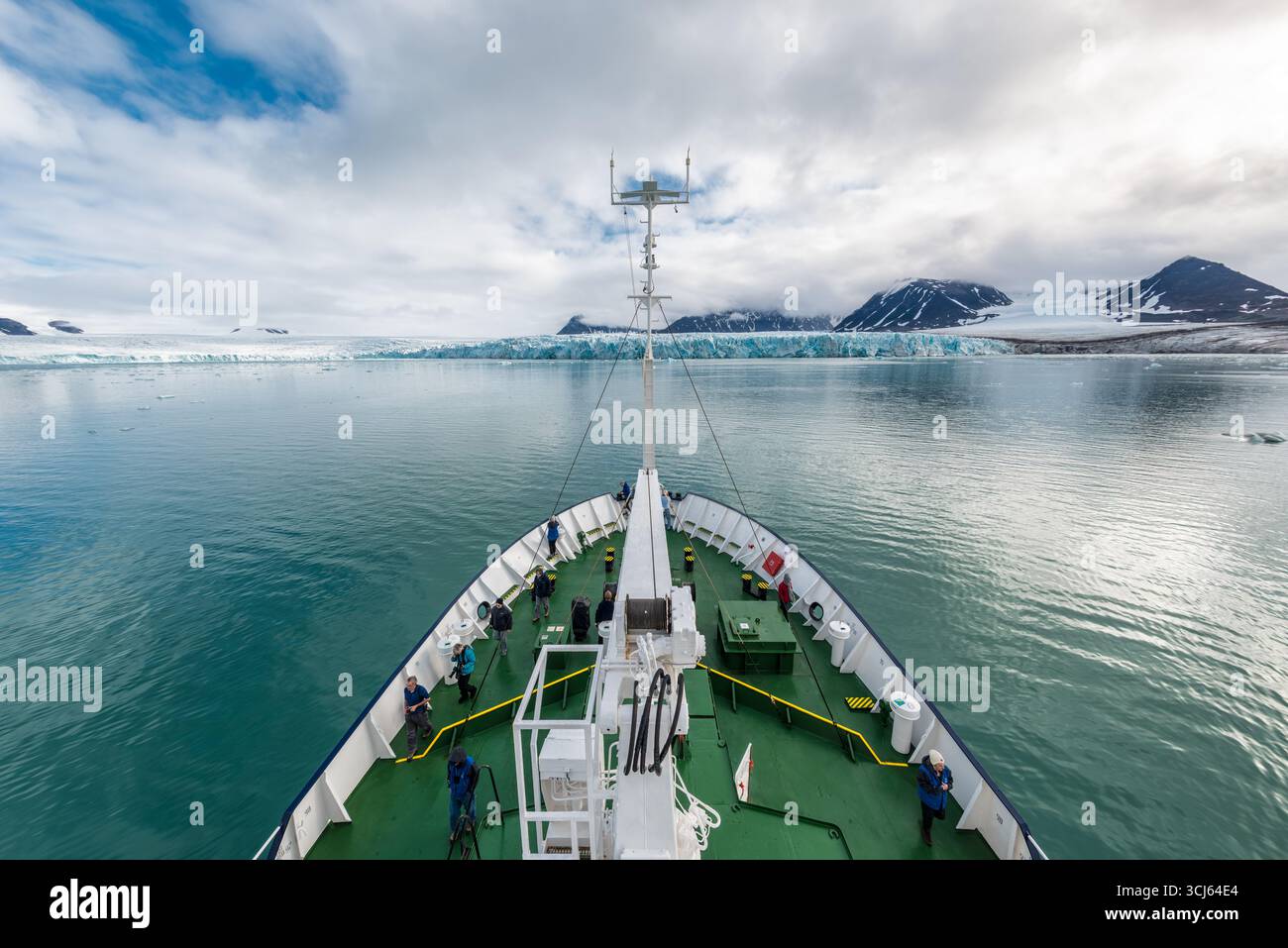Ghiacciaio Lilliehöökfjorden Spitsbergen Svalbard Norvegia // SPITSBERGEN, Svalbard — Una nave da ricerca si avvicina al ghiacciaio Lilliehöökfjorden a Spitsbergen, Svalbard, Norvegia. Il ghiacciaio, una vasta distesa di ghiaccio e neve, fa da sfondo alle tranquille acque artiche. Diversi individui sono visibili sul ponte della nave, osservando il paesaggio glaciale. Lilliehöökfjorden è conosciuta per le sue impressionanti formazioni glaciali ed è una destinazione popolare per le spedizioni artiche e la ricerca scientifica. L'arcipelago delle Svalbard si trova nell'Oceano Artico ed è caratterizzato dalla sua estrema estrema Foto Stock