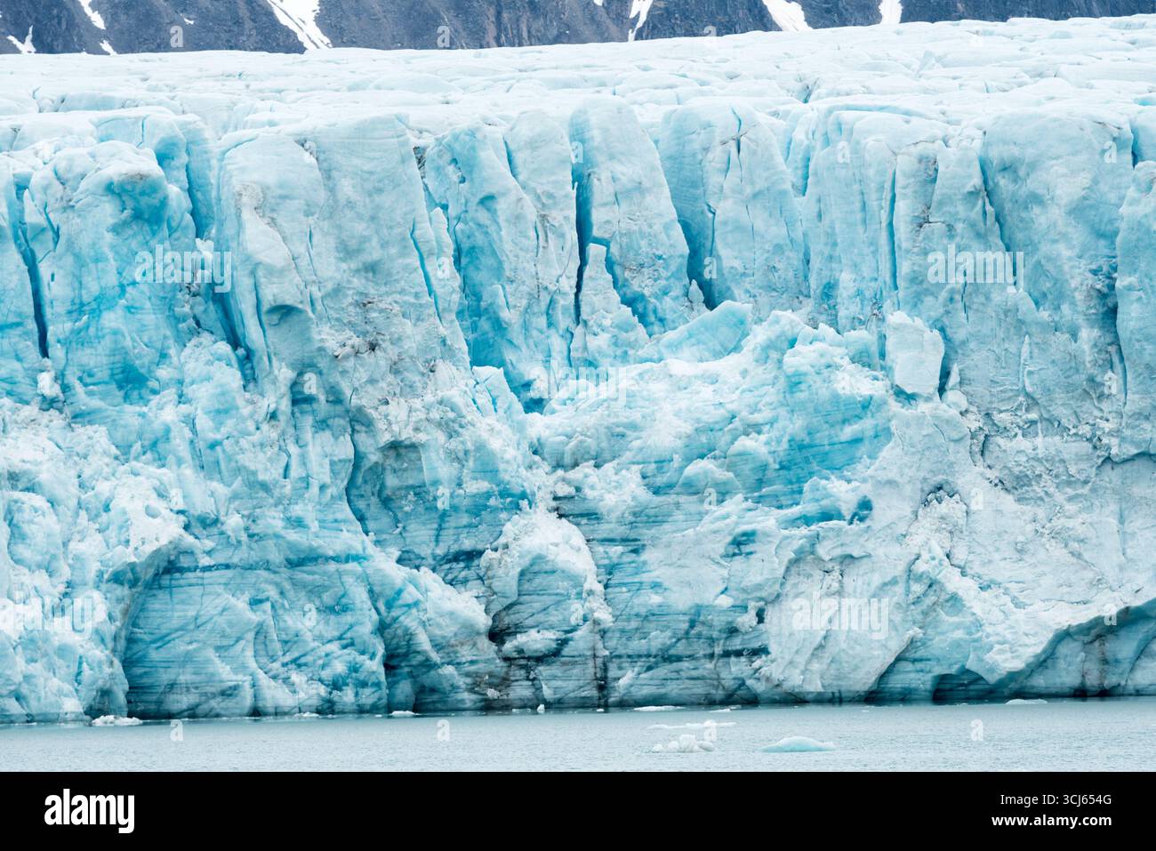 Ghiacciaio Lilliehöökfjorden Spitsbergen Svalbard Norvegia // LILLIEHÖÖKFJORDEN, Svalbard — il ghiacciaio Lilliehöökfjorden a Spitsbergen, Svalbard, Norvegia, è caratterizzato dalle sue spettacolari formazioni di ghiaccio e dalle tonalità blu intenso. Questo paesaggio glaciale fa parte dell'arcipelago delle Svalbard, un territorio norvegese situato nell'Oceano Artico. La regione è conosciuta per il suo ambiente polare unico, tra cui ghiacciai, fiordi e abbondante fauna selvatica. Il Lilliehöökfjorden è un ghiacciaio di sbocco significativo, che contribuisce ai processi glaciali dinamici dell'area. L'arcipelago delle Svalbard è una destinazione popolare per Una Foto Stock