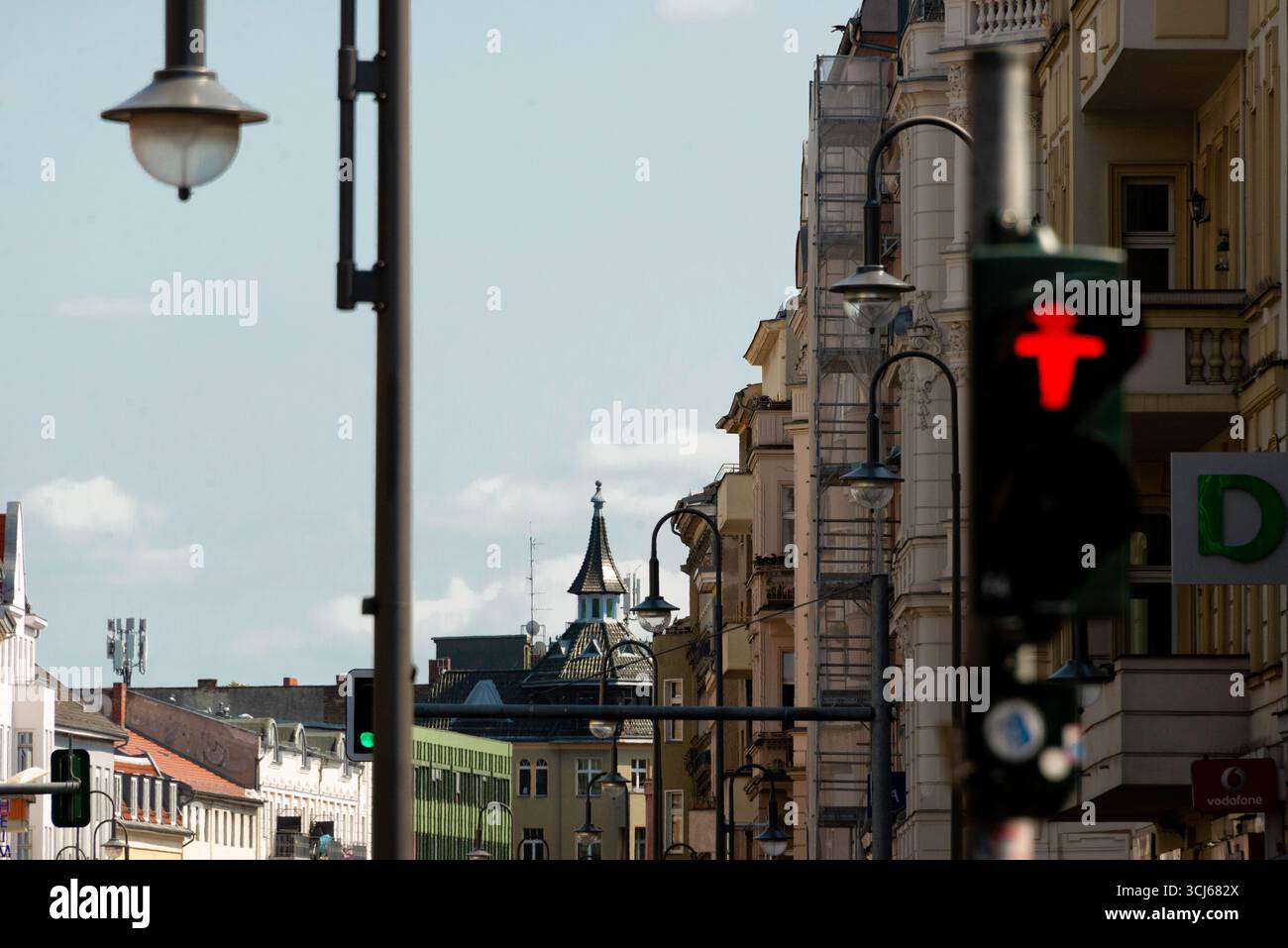 Una dinamica scena di strada che si affaccia sul vivace Karl Marx Straße a Neukölln, Berlino. La composizione utilizza una profondità di campo bassa, con una t sfocata Foto Stock