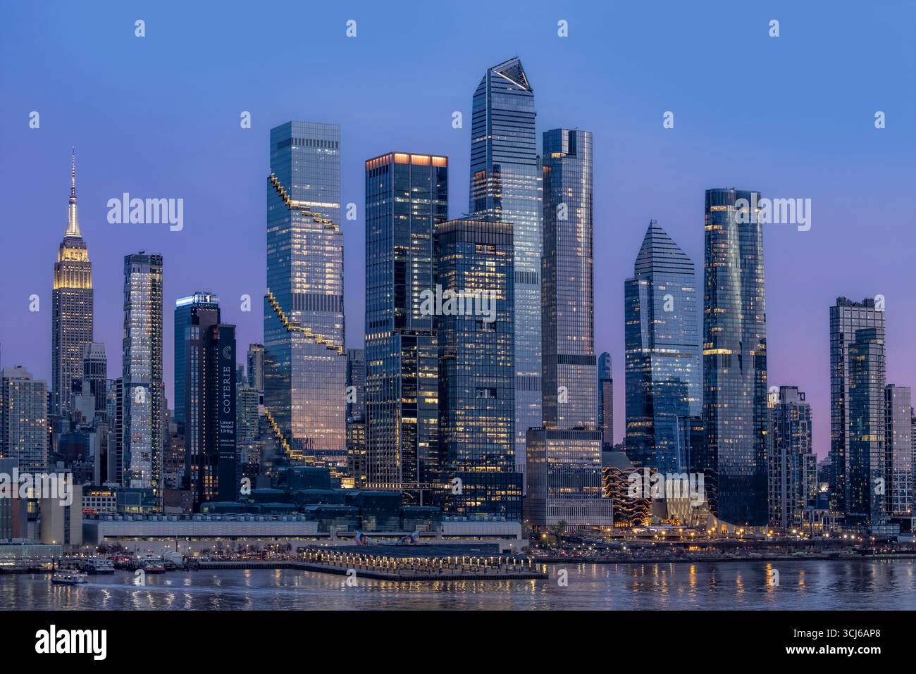 Città della luce, cielo di colore - la dispersione di Rayleigh dipinge lo skyline di New York con sfumature di rosso mentre il sole scende sotto l'orizzonte. Foto Stock