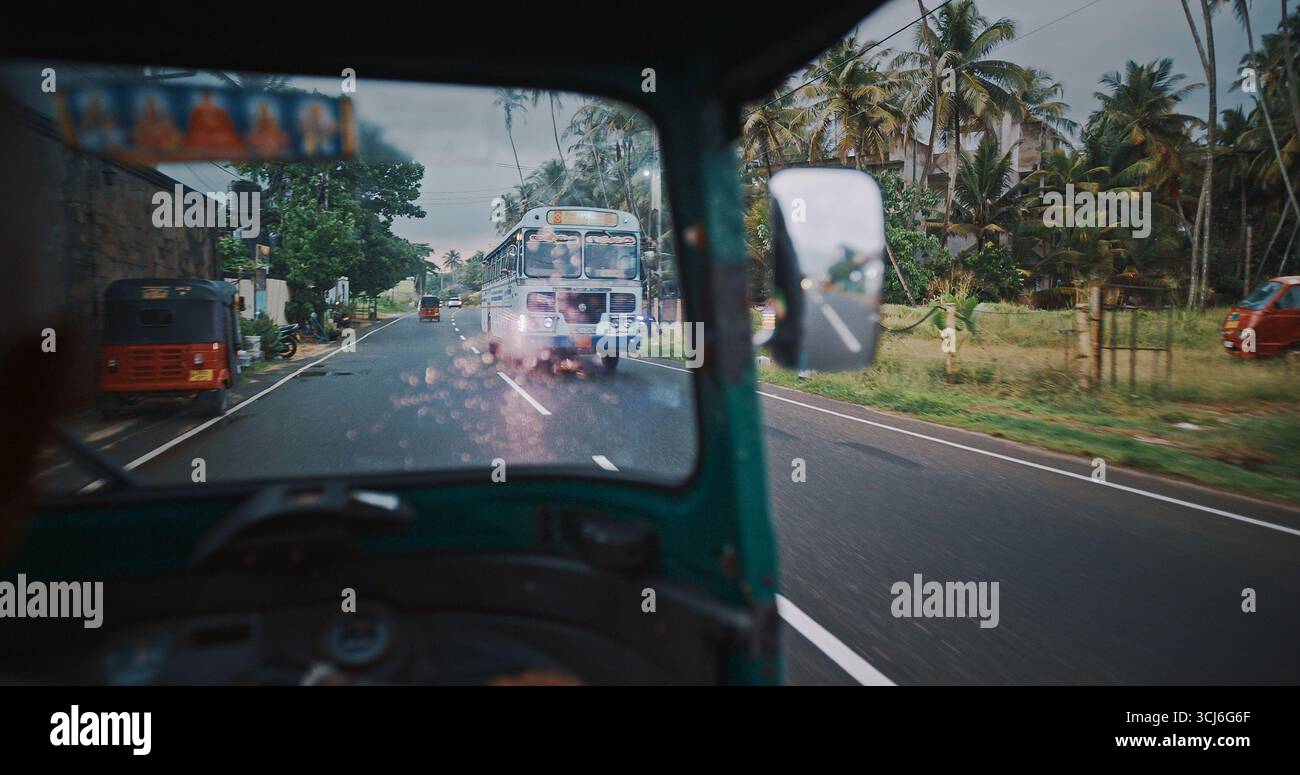 Tuk-tuk e autobus su una strada panoramica sotto il cielo nuvoloso Foto Stock