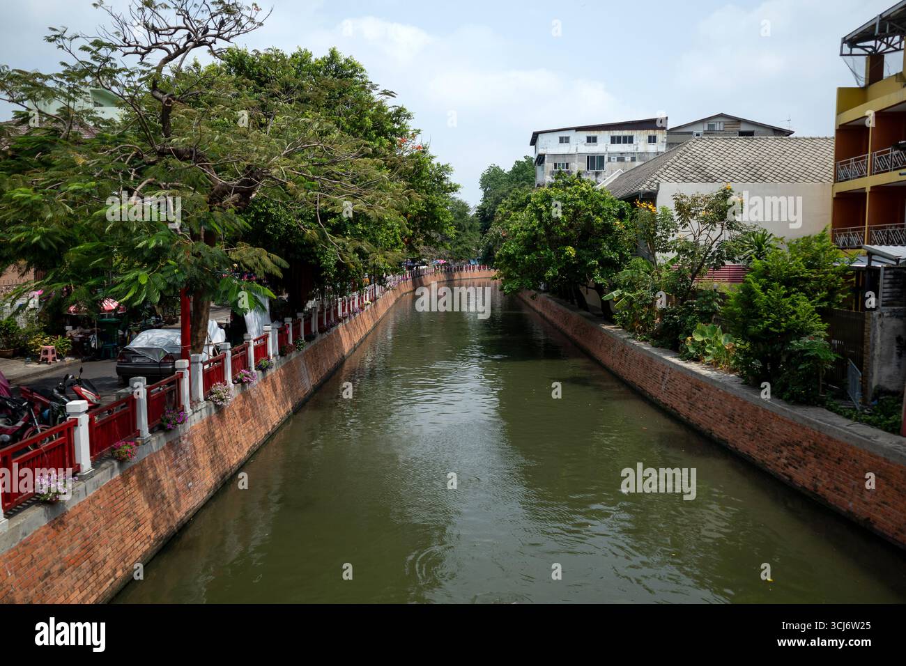 Una vista sul canale dell'acqua pulita con alberi lussureggianti al sole di metà pomeriggio Foto Stock