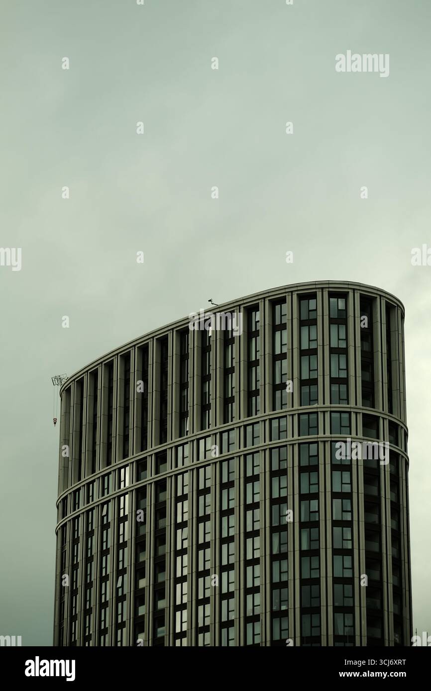 Moderno edificio cilindrico per uffici a Londra con finestre verticali e una facciata curva che mostra architettura contemporanea su un cielo limpido. Foto Stock