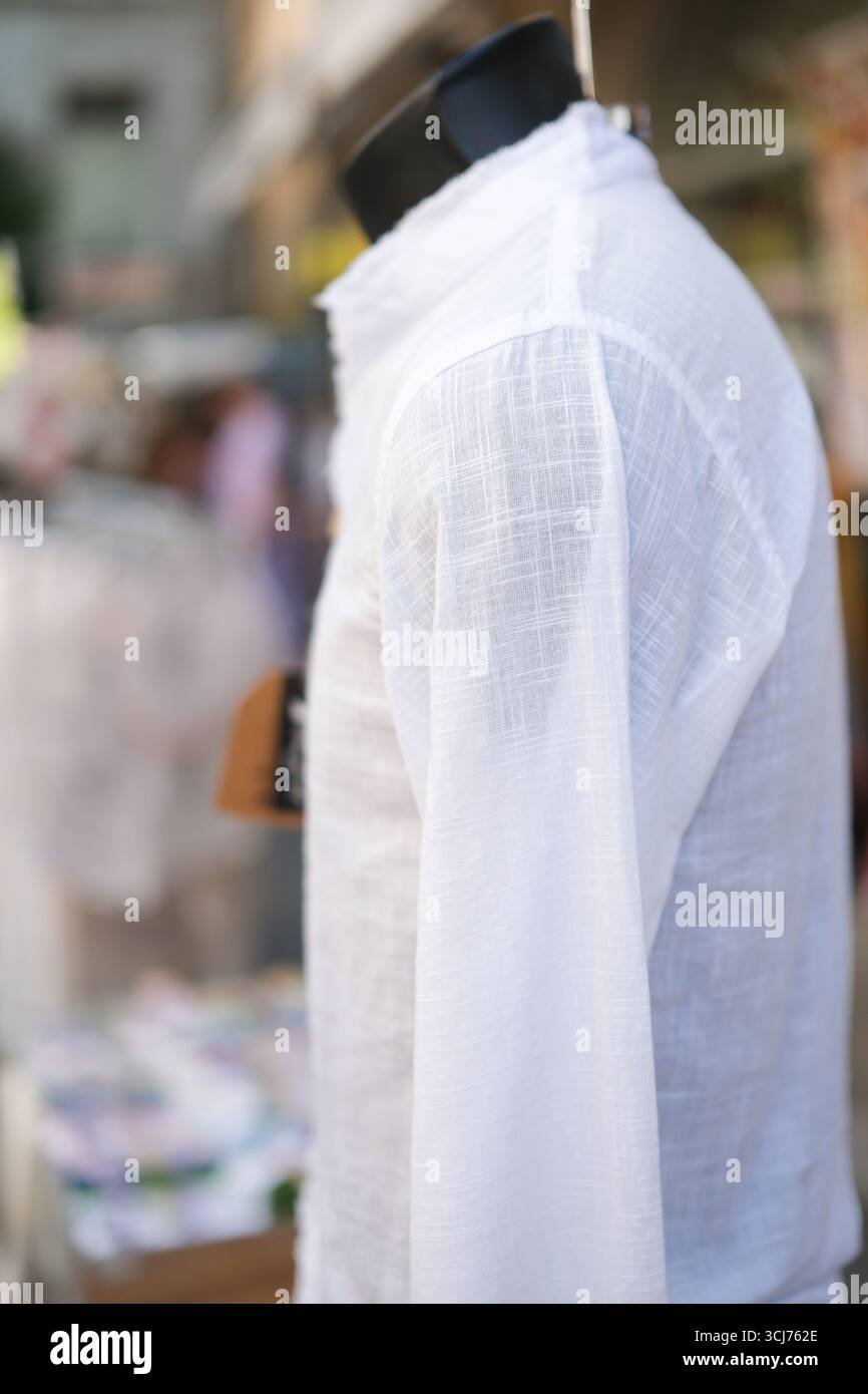 Camicia bianca in cotone o lino sul manichino. Consumo consapevole, stile di vita sostenibile. Look elegante per relax, passeggiate e turismo culturale. Foto Stock